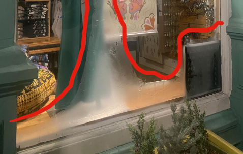 Store window showing "ice-olated" frost formation ❄️ on the inside of the windows mimicking the location of the objects displayed near the window. 